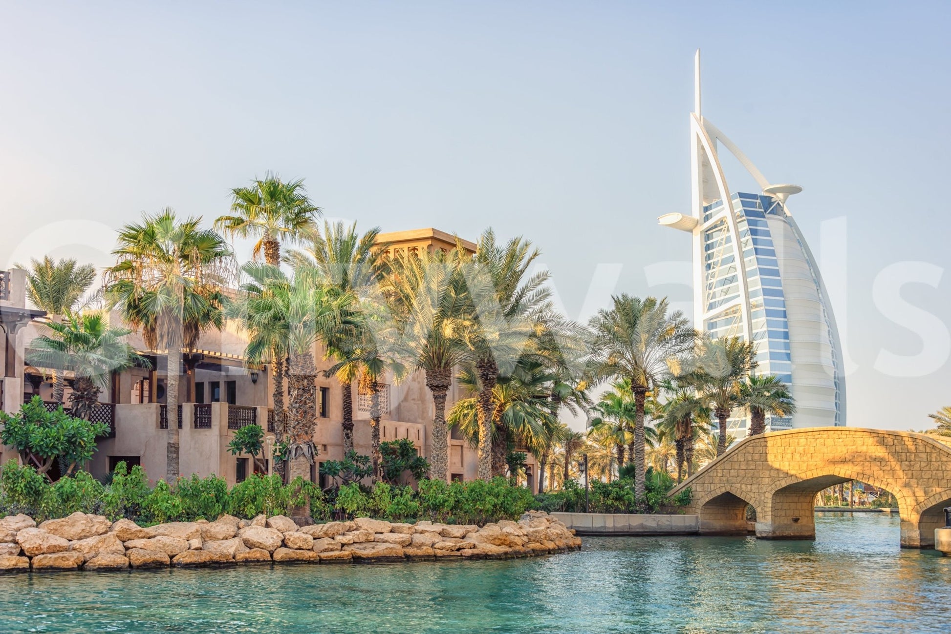 Dubai Oasis wallpaper mural close-up of the Burj Al Arab, palms and a stone bridge over turquoise water