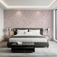 Dusty Rose Vines wallpaper of pink foliage behind a grey leather bed with chrome lamps and a marble bench