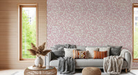 Dusty Rose Vines wallpaper with pink leaves behind a grey sofa with knit throws beside a slatted wood window