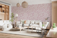 Dusty Rose Vines wallpaper of pink foliage behind a cream sofa and beanbag under woven rattan pendants