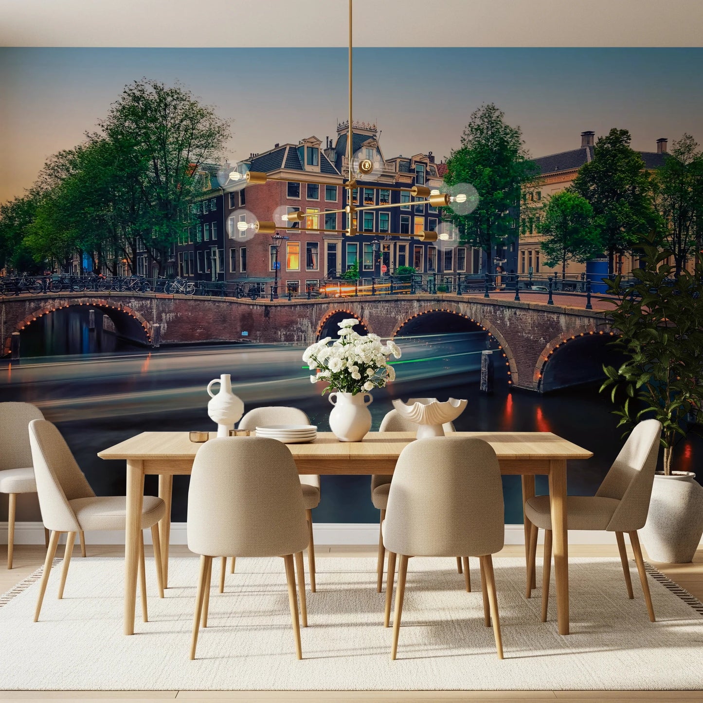 Dutch Canal Dreams wallpaper mural of an Amsterdam canal and arched bridge behind a wood dining table and beige chairs