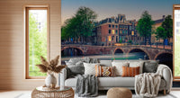 Dutch Canal Dreams wallpaper mural of dusk canal houses above a grey sofa piled with knit and tan throw pillows