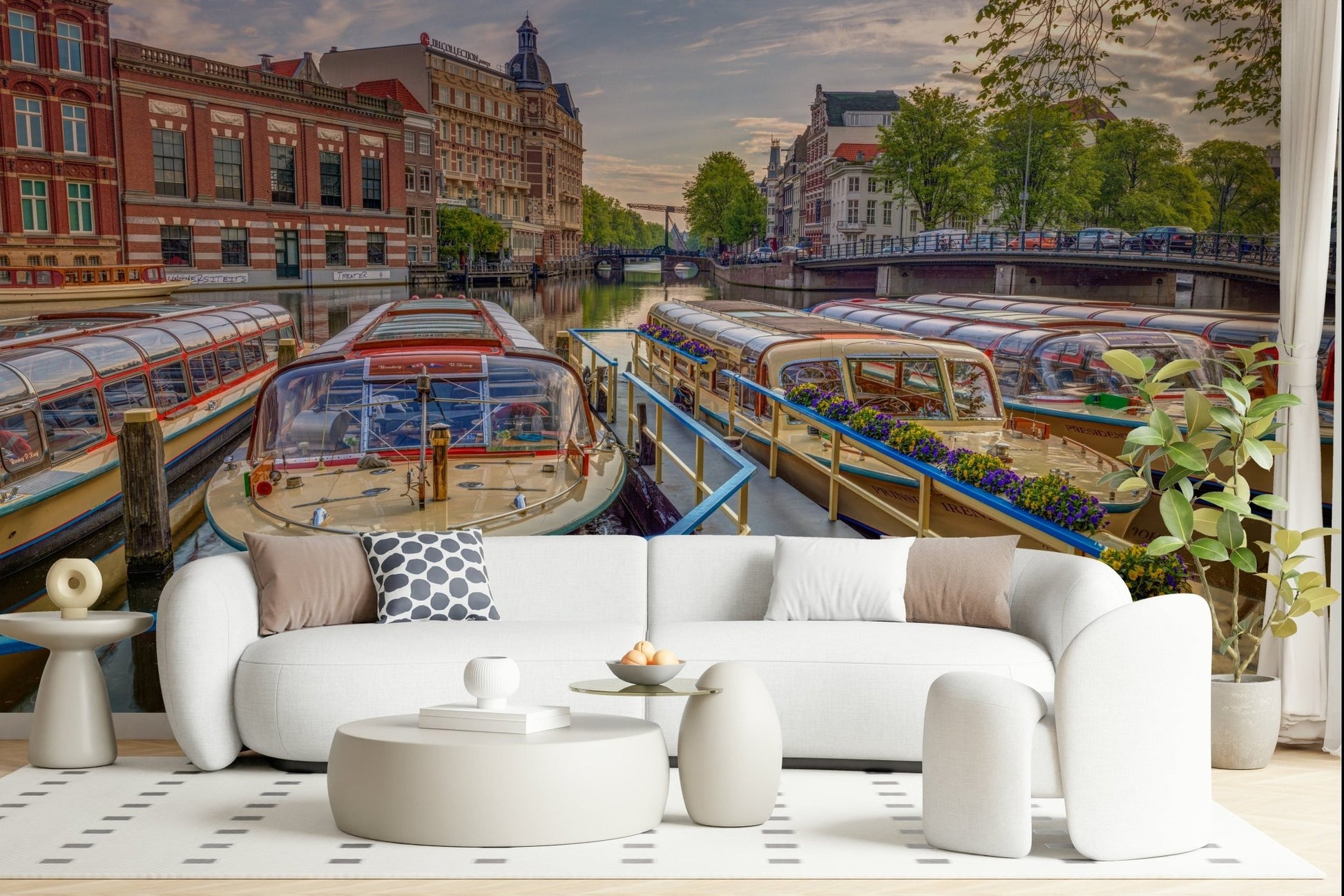 Dutch Waterways wallpaper mural of canal tour boats behind a white curved sofa and round tables in a living room