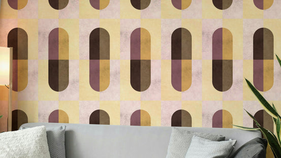 Earthy Geometric wallpaper in mustard, plum and brown capsule shapes above a grey sofa and snake plant