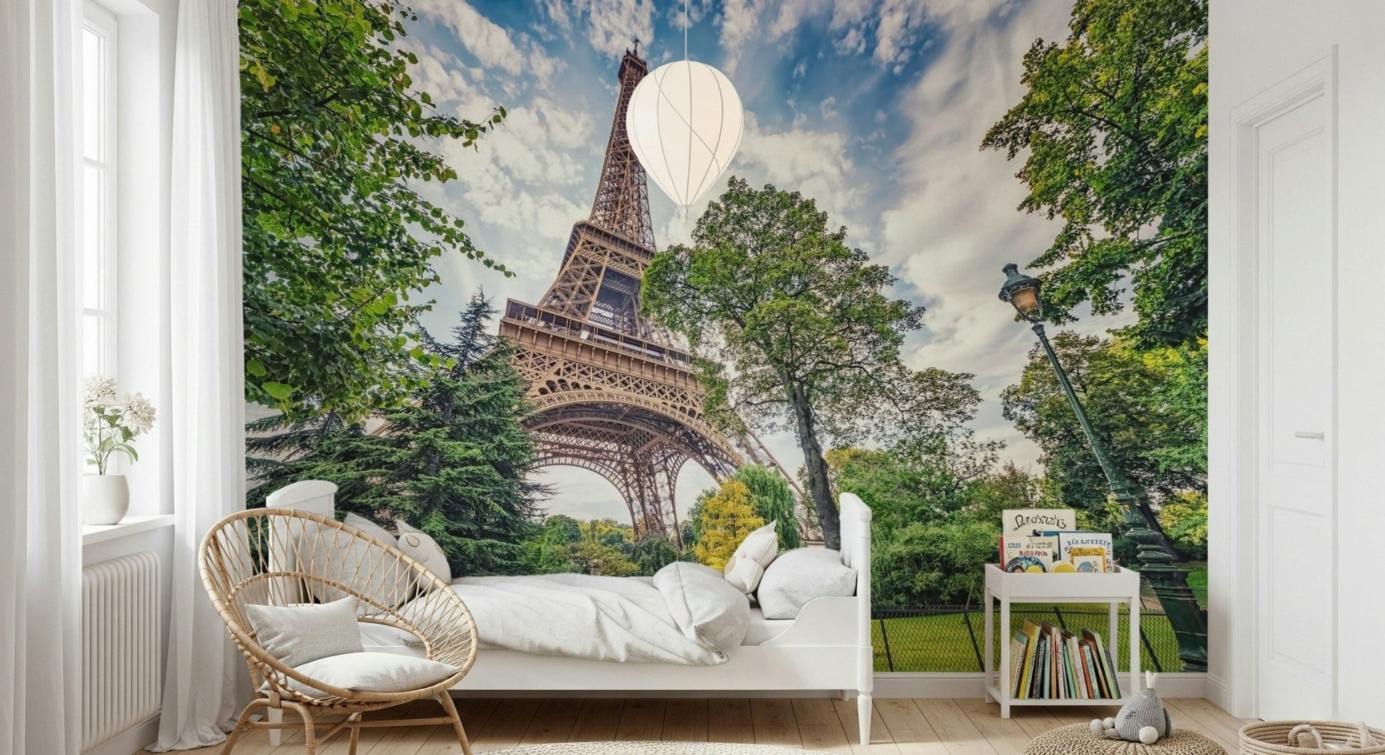 Eiffel Tower Greens wallpaper mural of the Eiffel Tower in a kids room with a white bed and rattan peacock chair