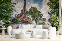 Eiffel Tower Greens wallpaper mural of the Eiffel Tower among trees behind a white curved sofa in a living room