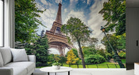 Eiffel Tower Greens wallpaper mural of the Eiffel Tower among green park trees behind a white sofa in a living room