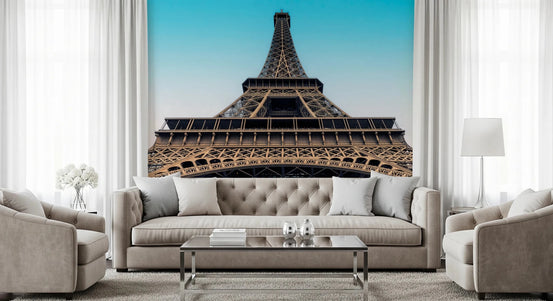 Eiffel's Azure Ascent wallpaper mural of the Eiffel Tower against a turquoise sky above a beige tufted sofa