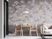Floral Branches Mountain wallpaper mural of white magnolias on gray behind a wood dining table for two beside a sofa