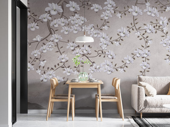 Floral Branches Mountain wallpaper mural of white magnolias on gray behind a wood dining table for two beside a sofa