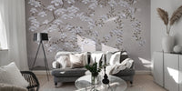 Floral Branches Mountain wallpaper mural of white magnolias on gray behind a tufted sofa and black tripod lamp
