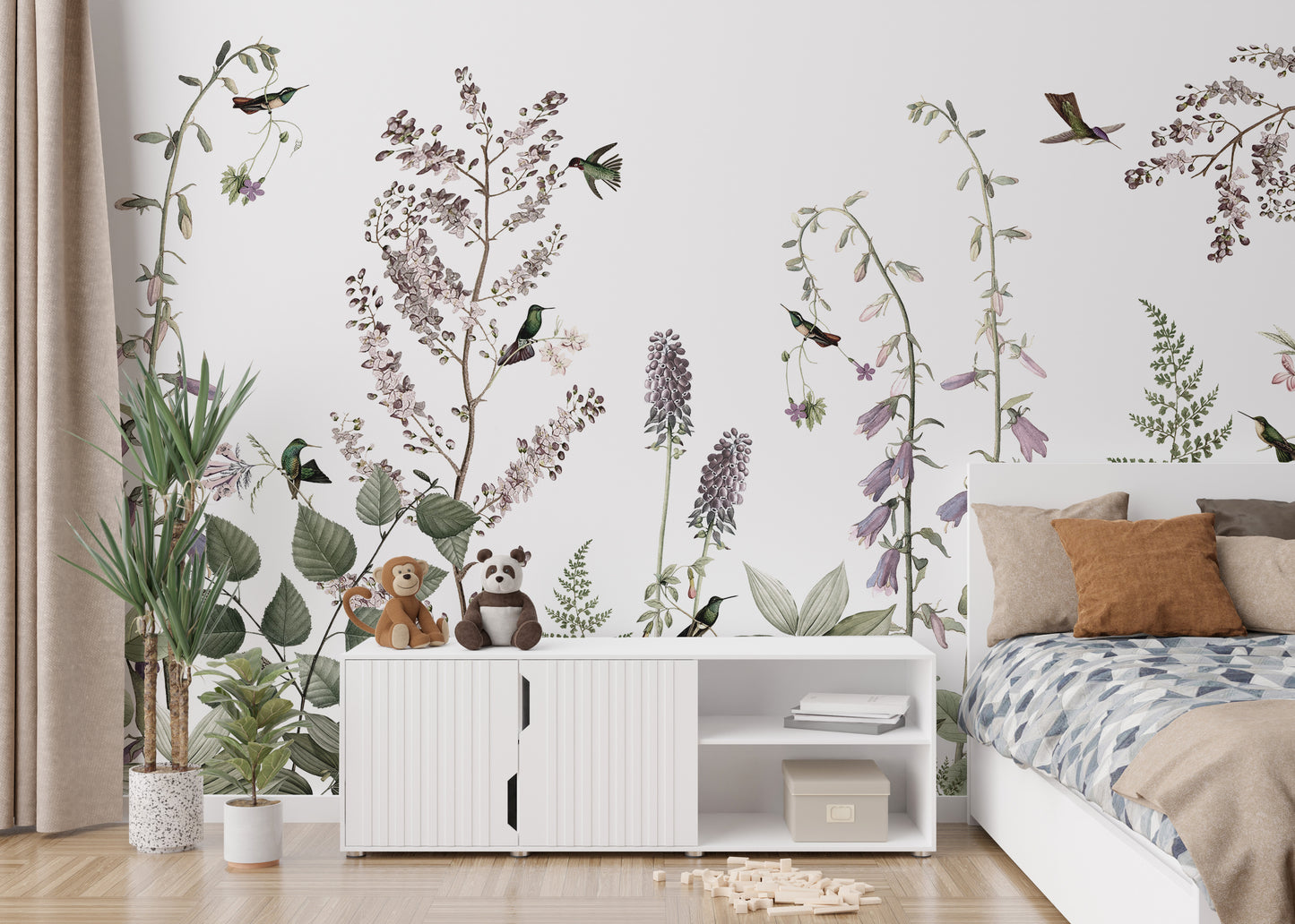 Hummingbird Hedge wallpaper mural of lilac flowers behind a white sideboard with plush toys in a kids bedroom