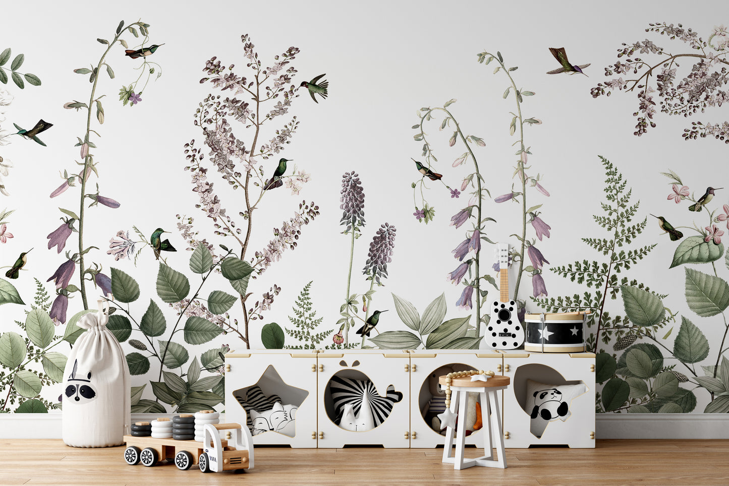 Hummingbird Hedge wallpaper mural of purple blooms and birds behind a white animal-cubby toy storage in a kids room