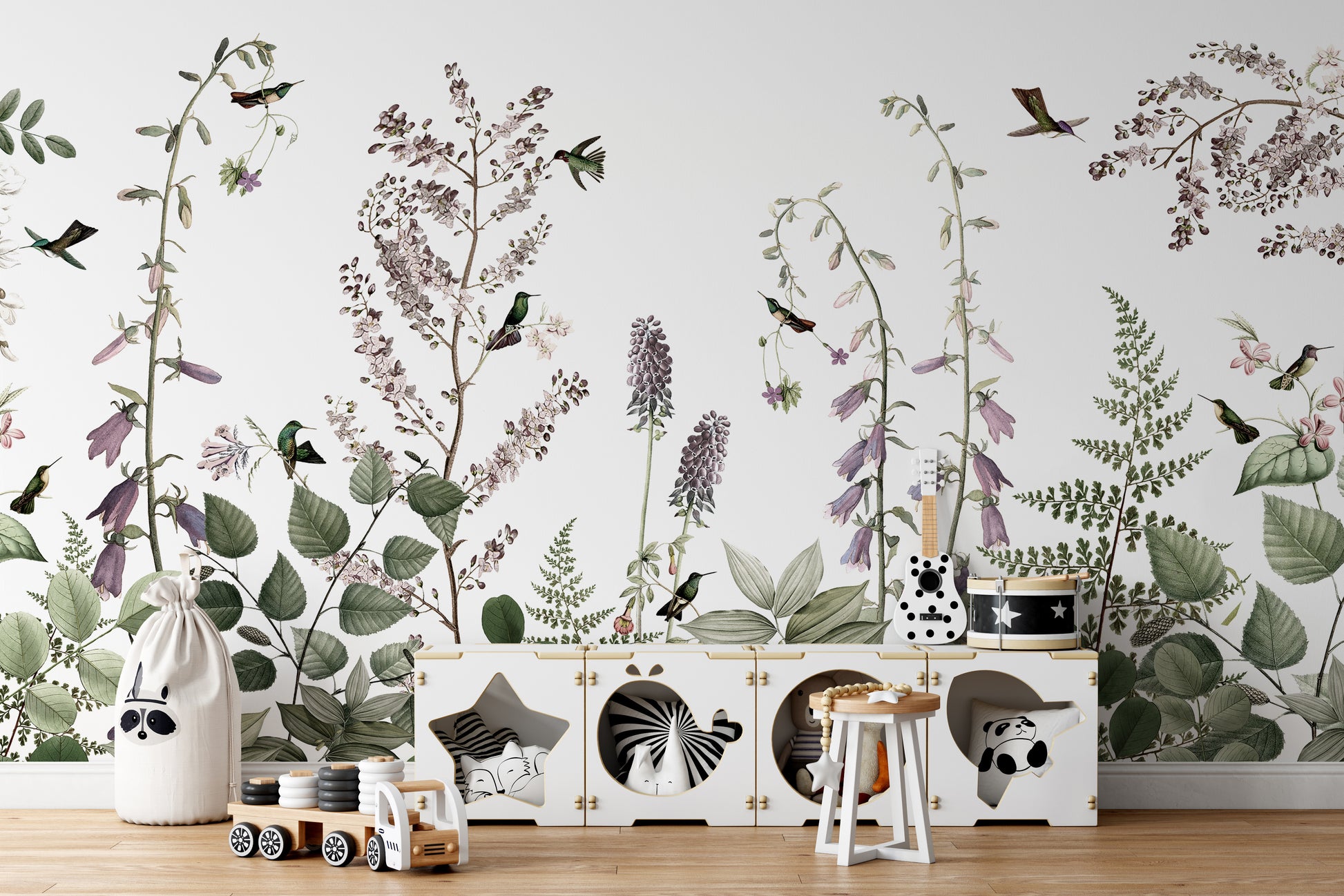 Hummingbird Hedge wallpaper mural of purple blooms and birds behind a white animal-cubby toy storage in a kids room