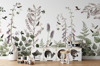 Hummingbird Hedge wallpaper mural of purple blooms and birds behind a white animal-cubby toy storage in a kids room