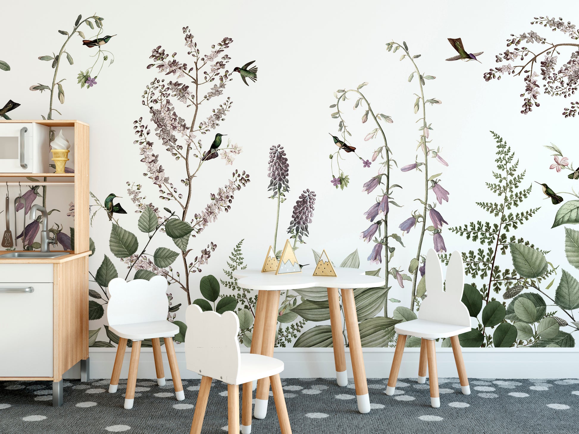 Hummingbird Hedge wallpaper mural with lilac wildflowers and hummingbirds in a kids playroom with bear-ear chairs