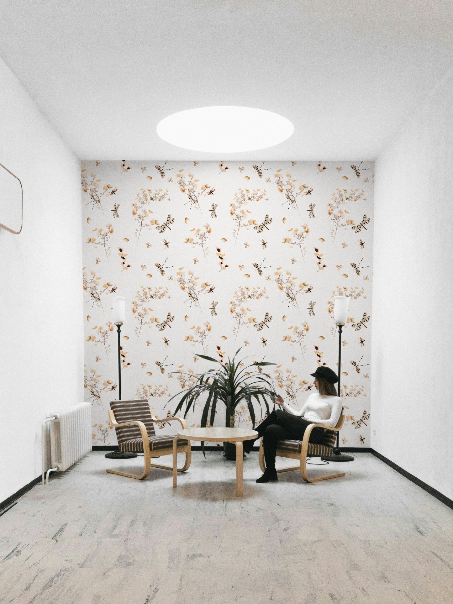 An angled shot of a wall with floral and insect wallpaper

