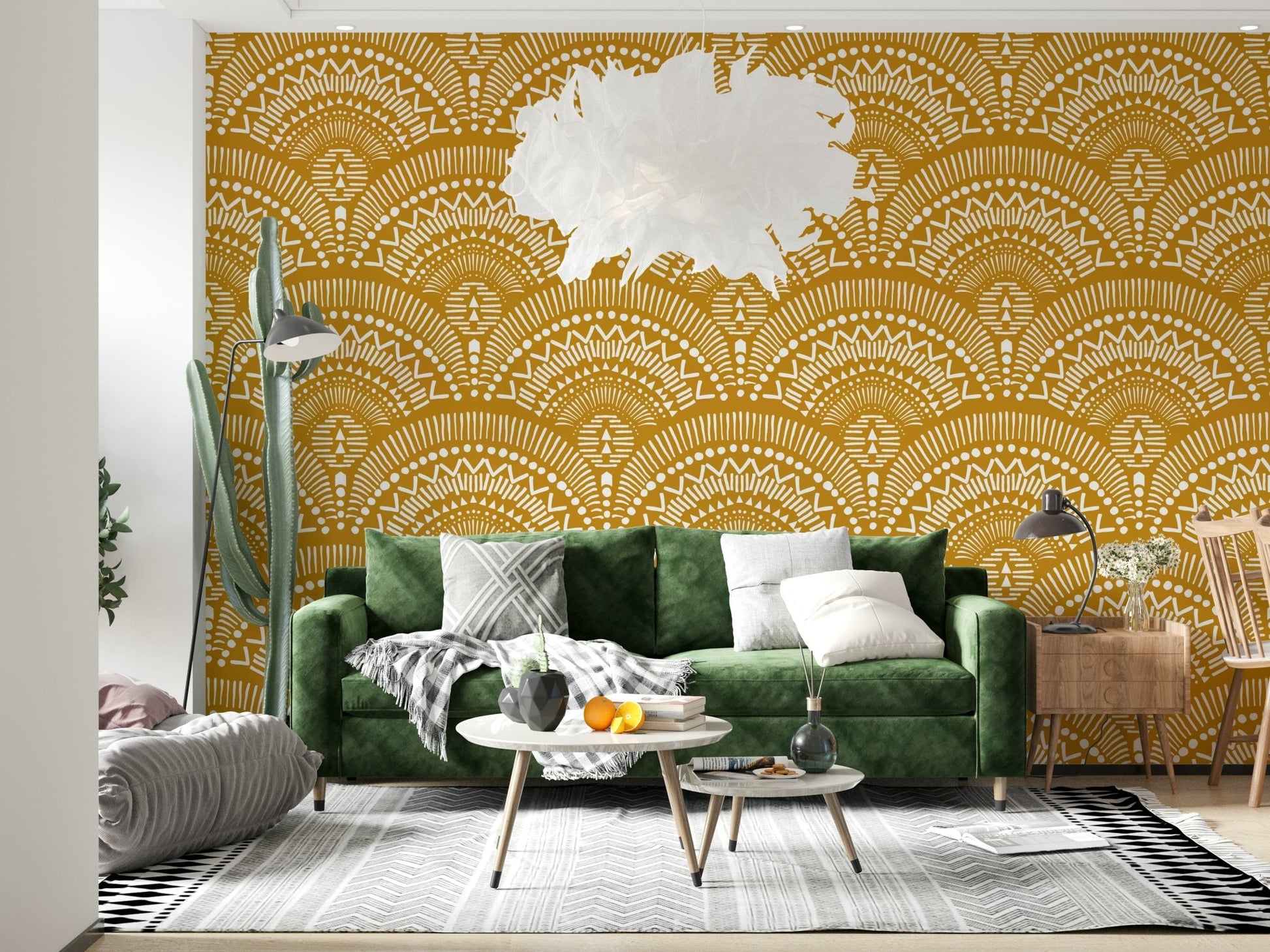 Ethnic Echoes wallpaper in mustard and white boho fans behind a dark green velvet sofa in a living room