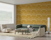 Ethnic Echoes wallpaper in mustard and white behind a sage green sofa and cream chair in a living room