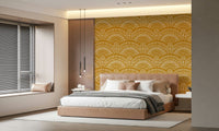 Ethnic Echoes wallpaper in mustard yellow behind a tan upholstered bed with pendant lights in a bedroom