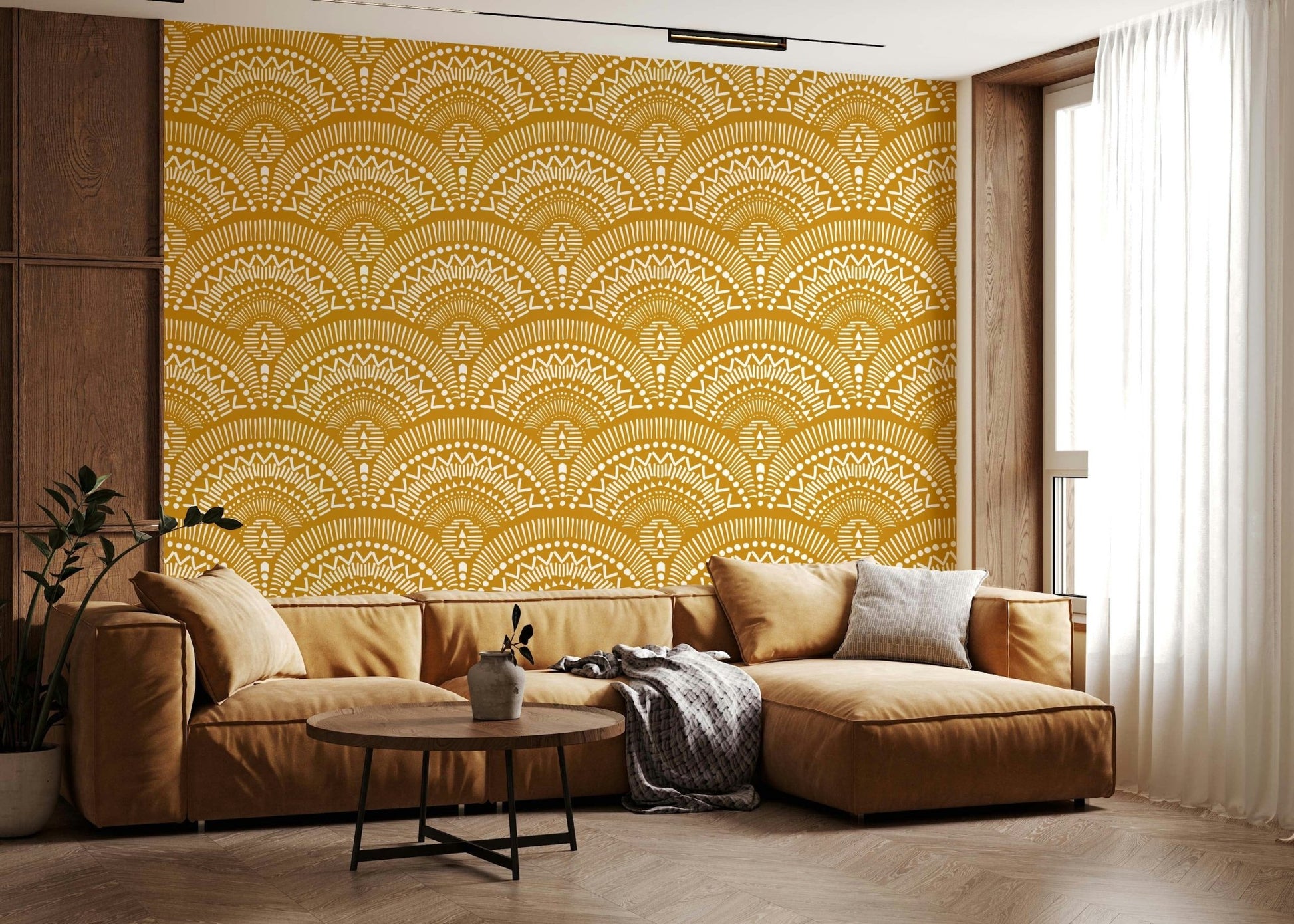 Ethnic Echoes wallpaper in mustard and white behind a caramel leather sectional sofa in a living room