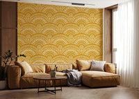 Ethnic Echoes wallpaper in mustard and white behind a caramel leather sectional sofa in a living room