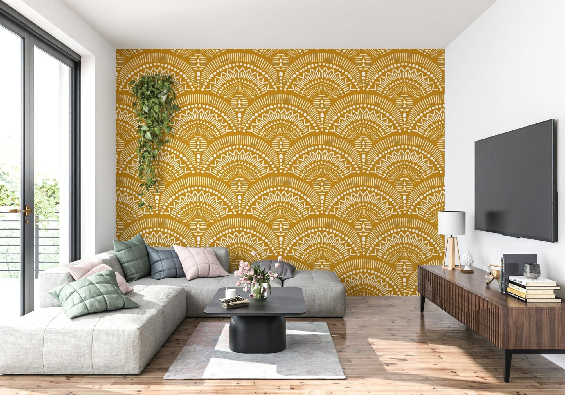 Ethnic Echoes wallpaper in mustard yellow behind a grey sectional sofa and TV in a bright living room