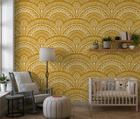 Ethnic Echoes wallpaper in mustard yellow behind a white crib and striped armchair in a nursery
