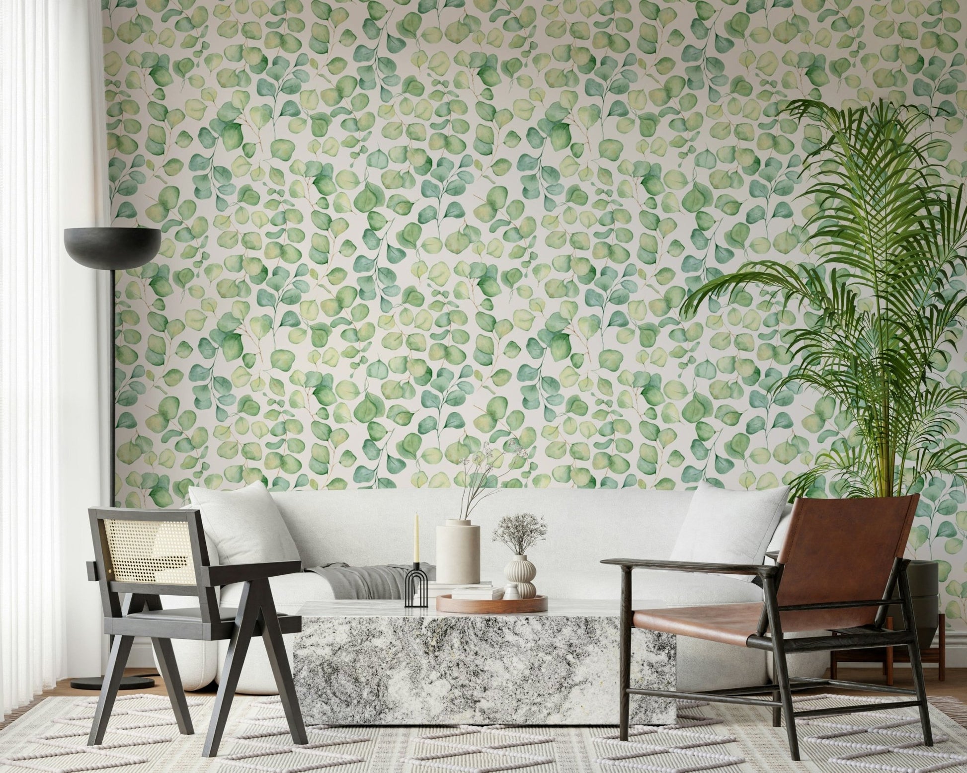 Nursery wall decor with soft green eucalyptus designs and white furniture.