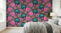Exotic Bloom wallpaper behind a white and grey bed with a macrame throw and bedside lamp