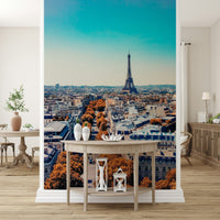 Fall in Paris wallpaper mural of the Paris skyline behind a demilune console table with lanterns in an entryway