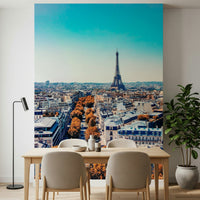 Fall in Paris wallpaper mural of the Paris skyline behind a dining table, beige chairs and floor lamp