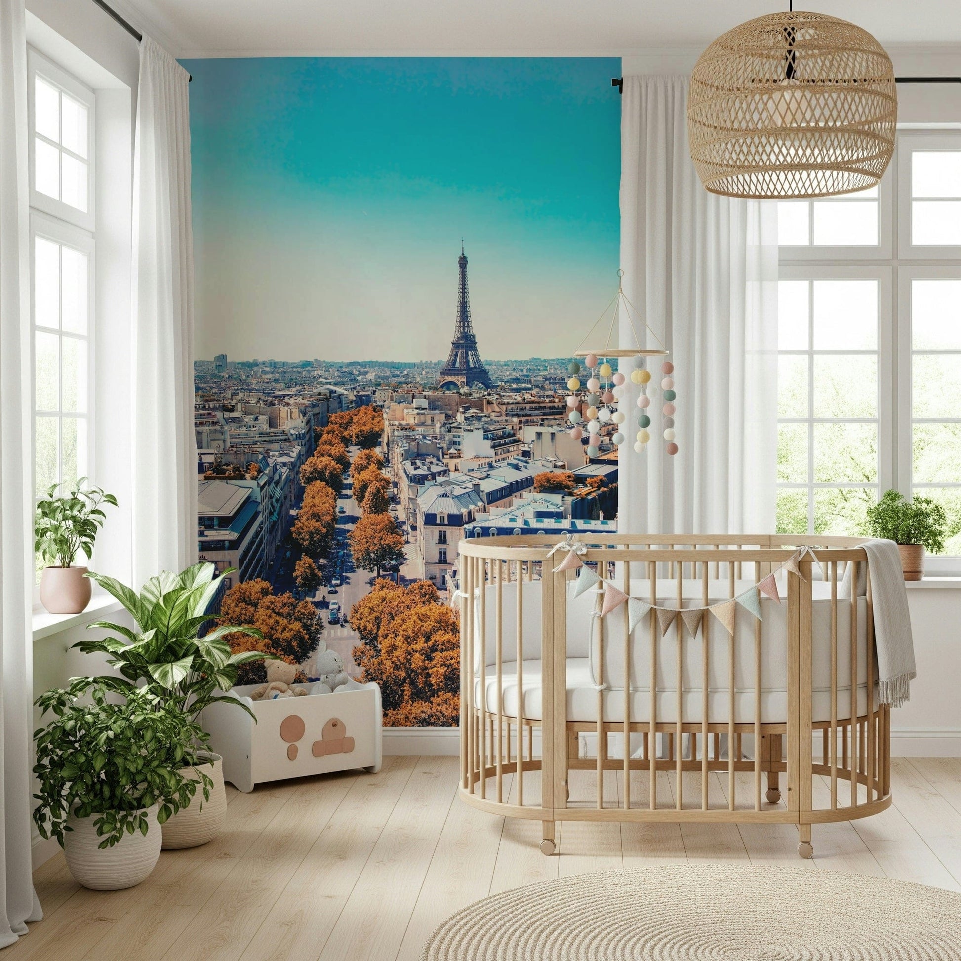 Fall in Paris wallpaper mural with Eiffel Tower beside an oval wood crib in a bright nursery
