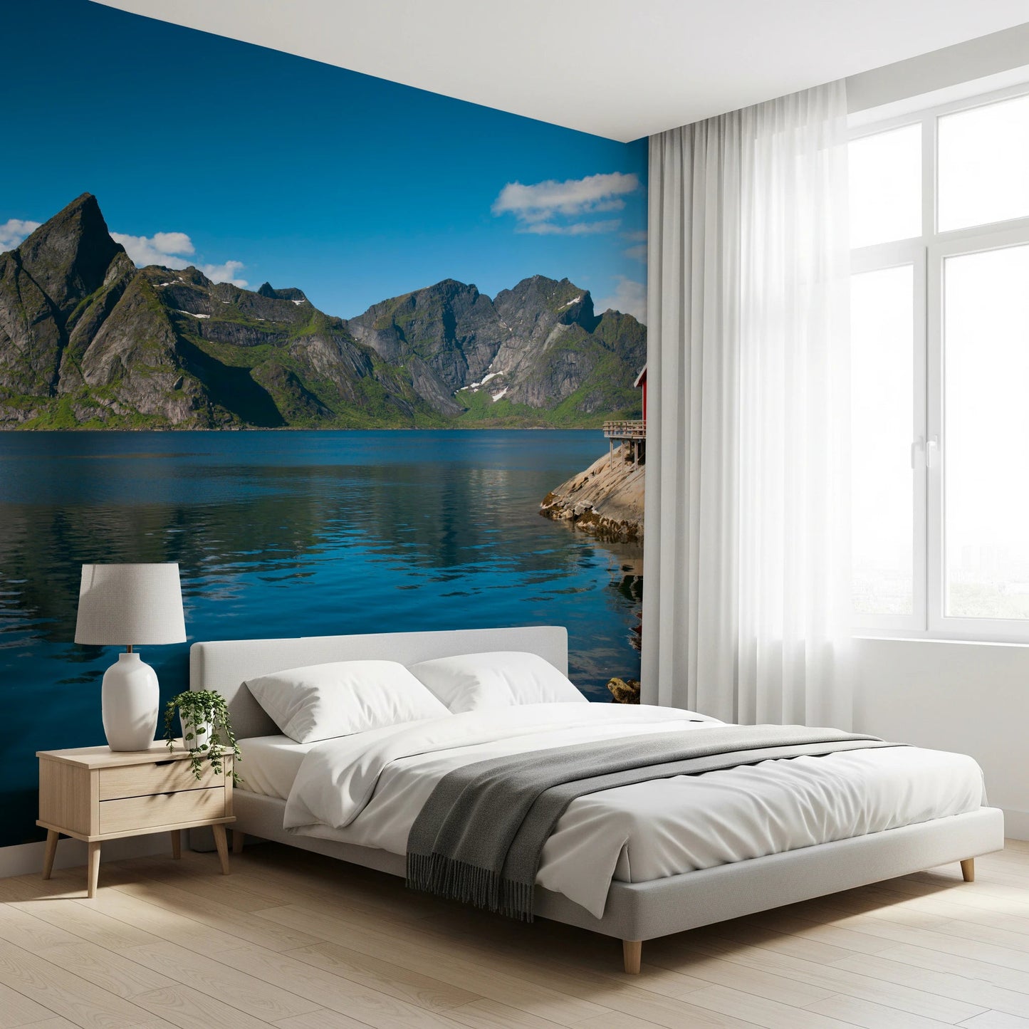 Fishing huts wallpaper mural of a blue fjord and mountains behind a white platform bed in a sunlit bedroom