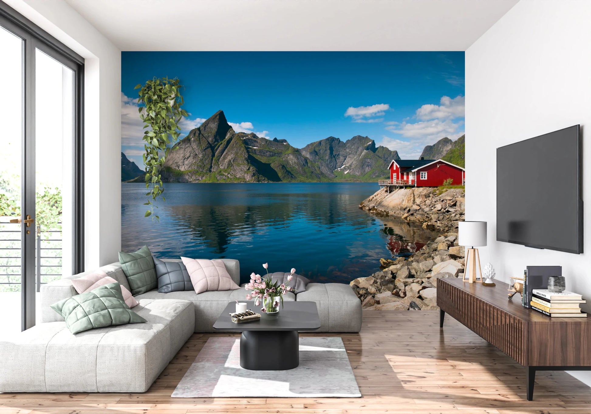 Fishing huts wallpaper mural of a blue fjord and red cabin behind a grey sectional sofa and wood TV console in a living room