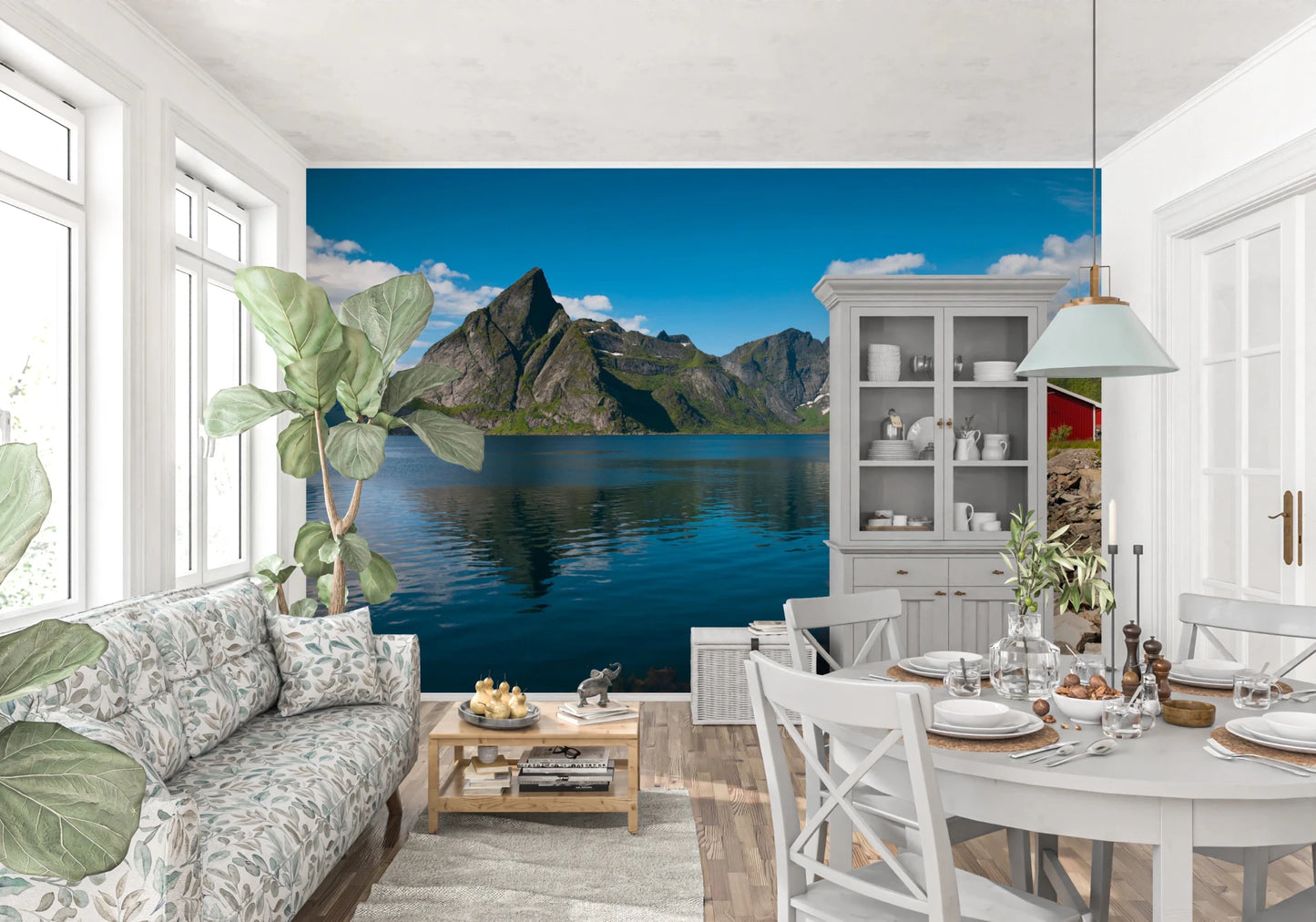 Fishing huts wallpaper mural of a fjord and red cabin in a white living-dining room with a floral sofa and round table