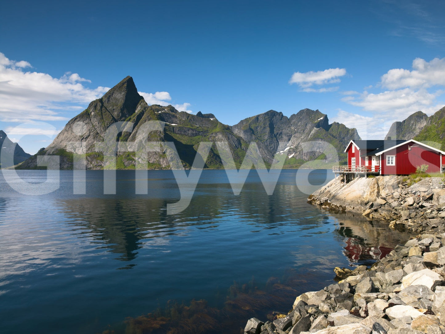 Fishing huts wallpaper mural shown as a full-wall mural of a blue fjord, grey peaks and red rorbu cabins on the rocks