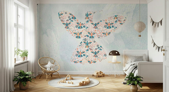 Floral Hummingbird wall mural in teal and coral on pale blue behind a rattan chair in a bright nursery