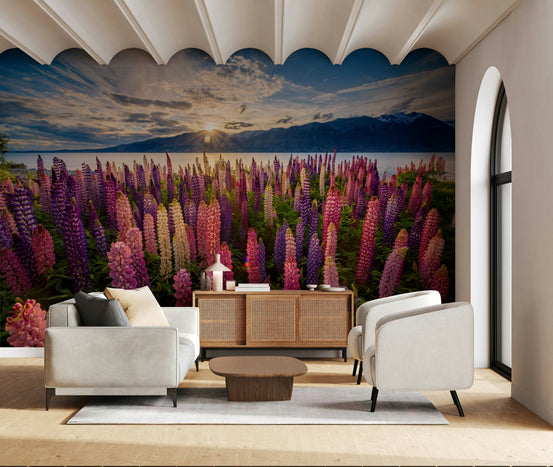 Floral Lake Dawn wallpaper mural of pink and purple lupines by a lake at sunset, behind a grey sofa and armchair in an arched living room