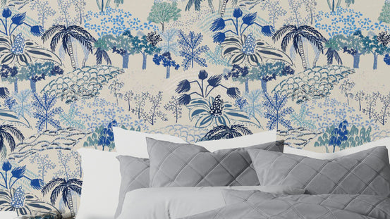 Florentine Fresco wallpaper of blue and teal trees on a cream ground behind a bed with grey quilted pillows