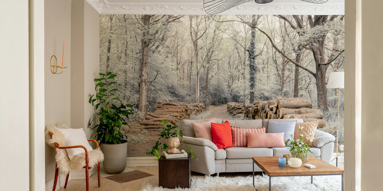 Wall mural of a woodland path with stacked logs.

