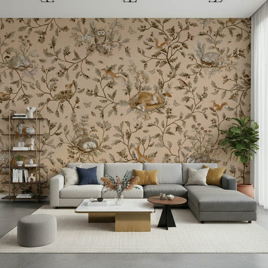 Forest Slumber wallpaper mural in sandy beige with owls and foxes behind a grey sectional and gold coffee table