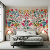 Frida's Garden wallpaper mural behind a beige bed flanked by two round globe lamps in a bedroom