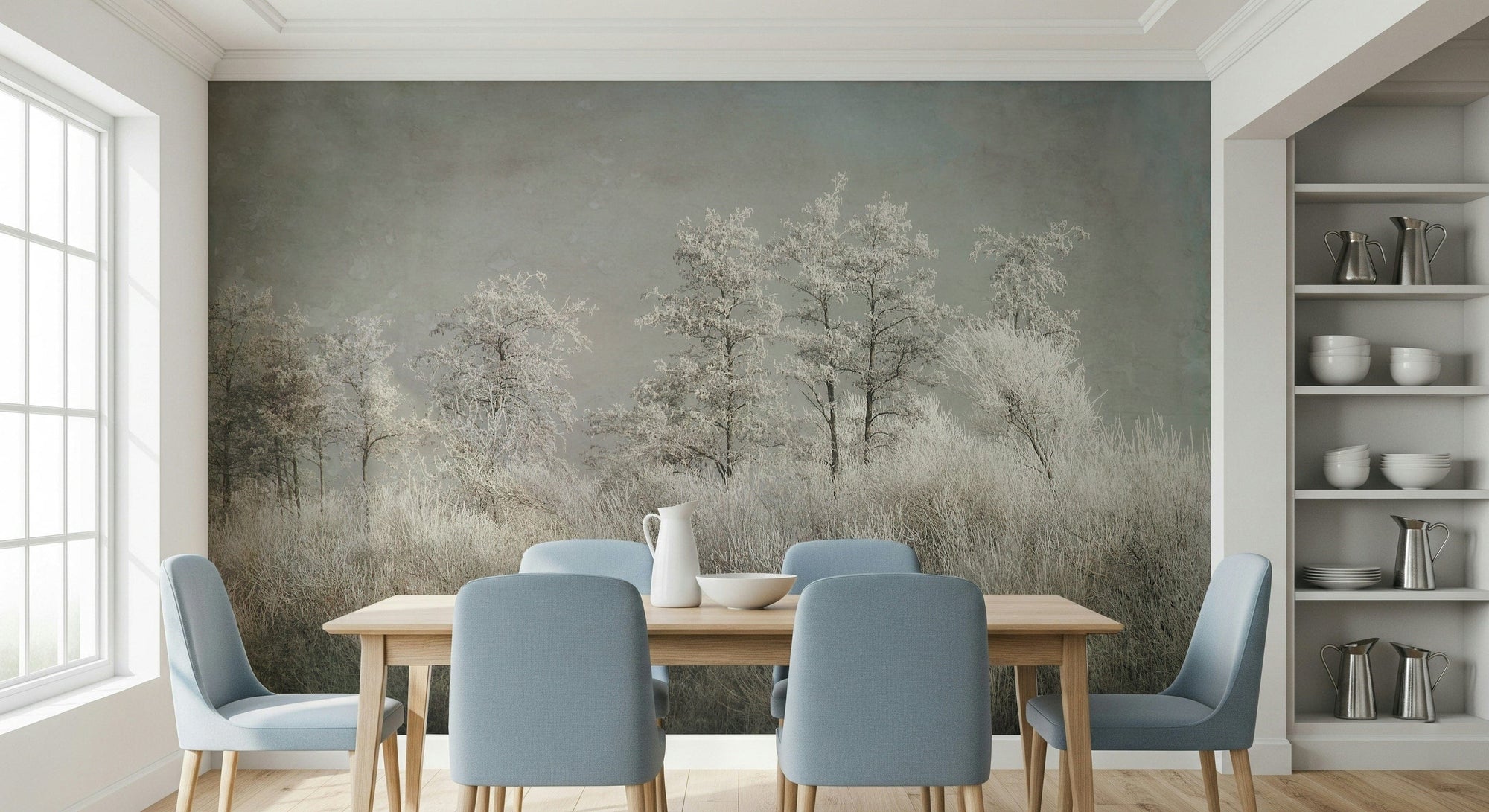Frosted Stillness wallpaper mural of frosty white trees and pale grasses behind a wood table and blue chairs