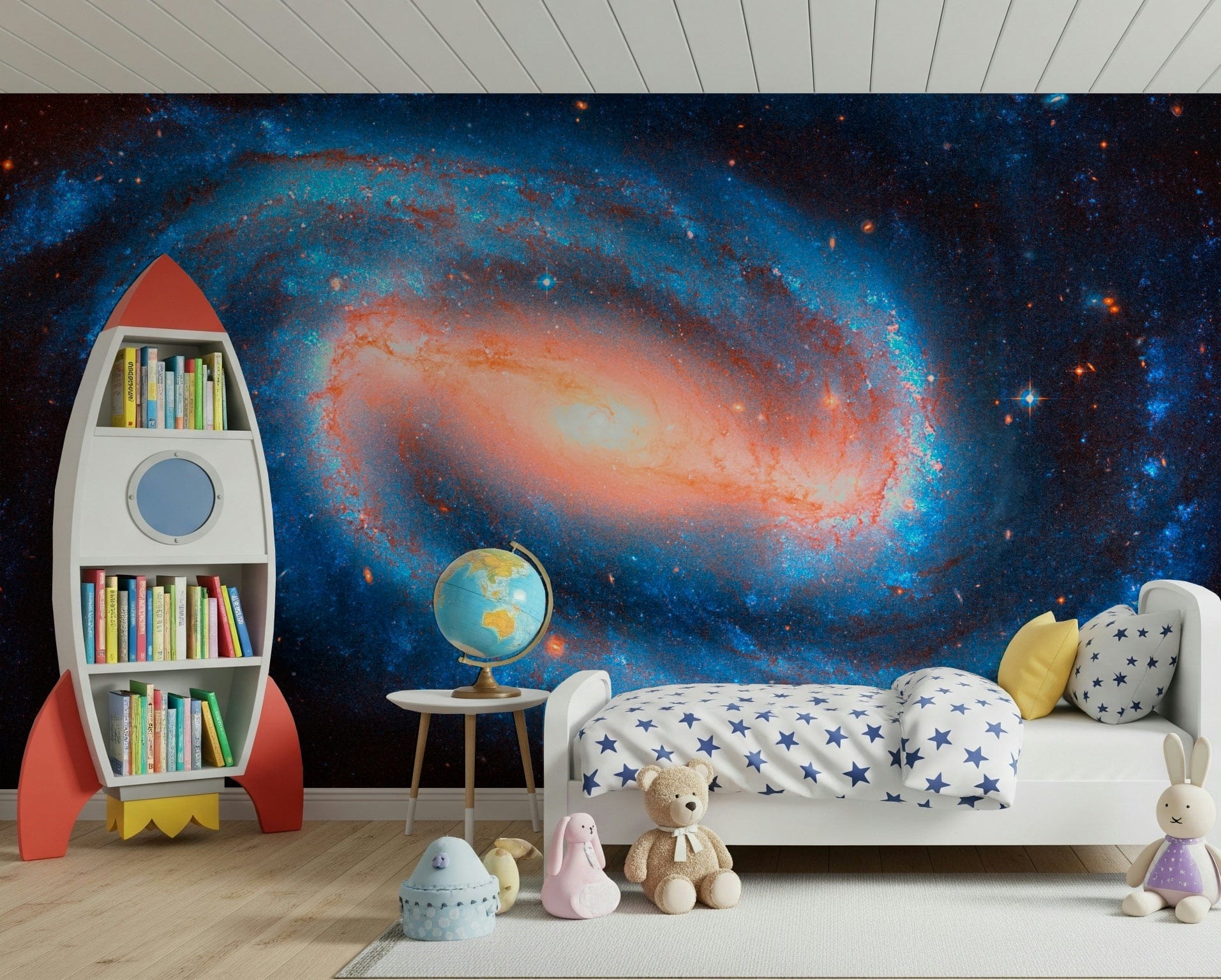 Galaxy Dream wallpaper mural of a blue and orange galaxy behind a white kids bed and red rocket bookshelf