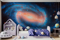 Galaxy Dream wallpaper mural of a blue spiral galaxy with a glowing core in a kids room with a lilac bed