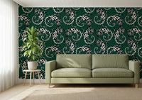 Gecko Groove wallpaper in dark green with white geckos behind a sage green sofa in a bright living room