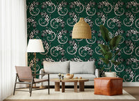 Gecko Groove wallpaper in green behind a grey sofa with a leather pouf and rattan pendant in a living room