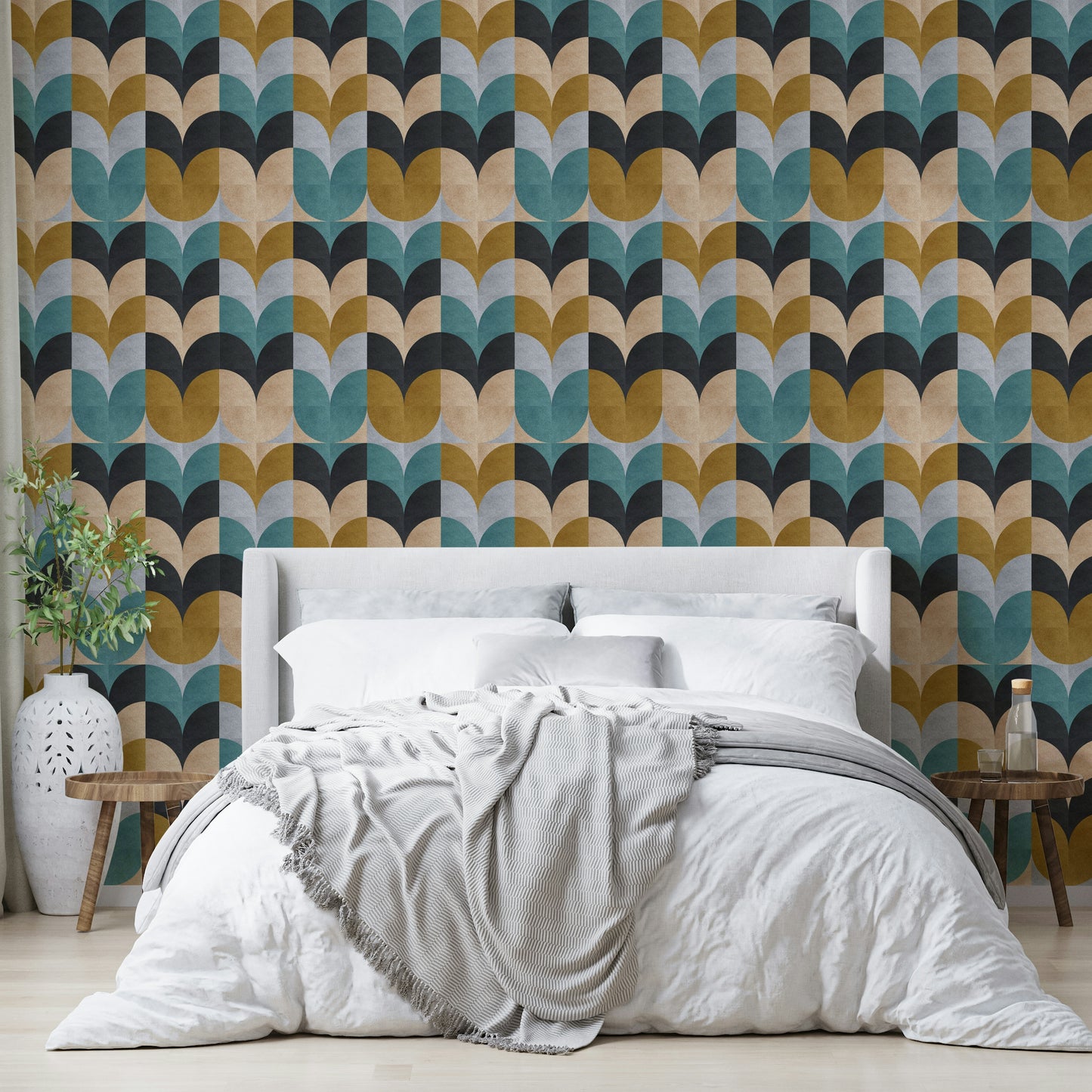 Geometric Art wallpaper of teal and ochre petals behind a cream upholstered bed with a grey striped throw