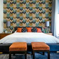 Geometric Art wallpaper of teal and mustard petals behind a black platform bed with orange polka-dot pillows